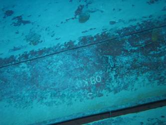 Large section of hull in debris field with "08KO" painted on plating